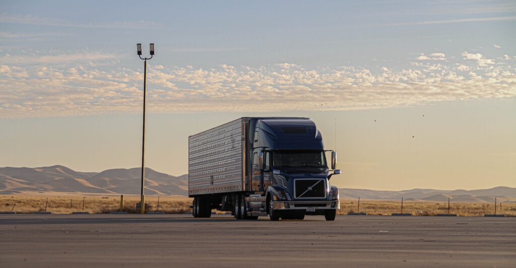 Black commercial truck traveling on an open road